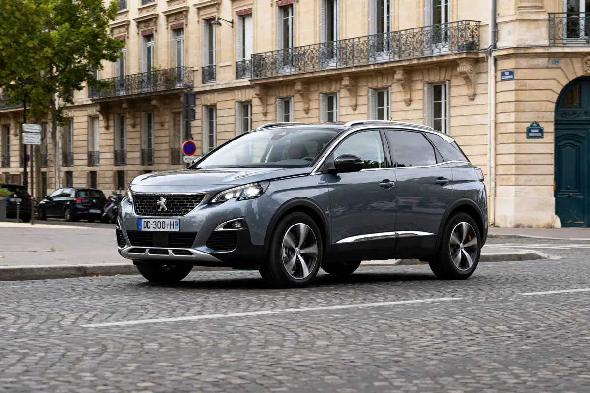SUV gris 3008 Peugeot automatic circulant devant bâtiments historiques en ville