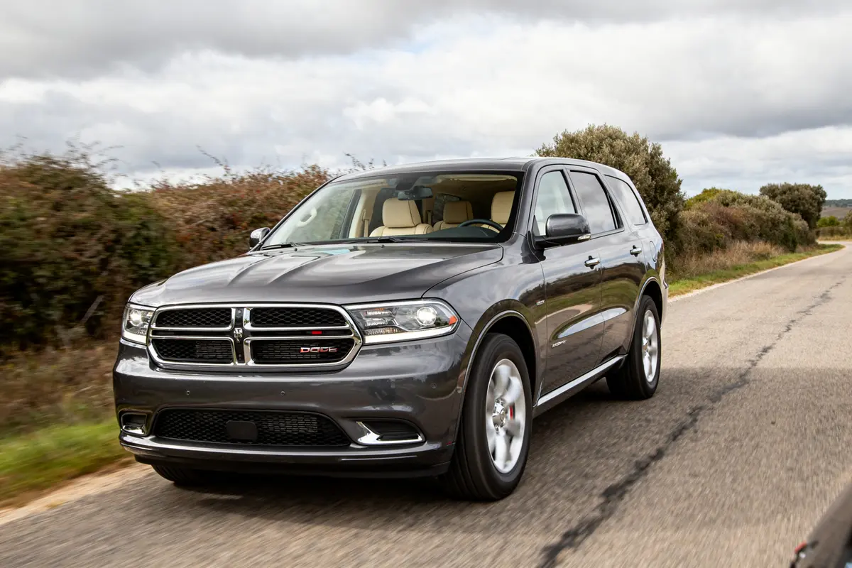 SUV gris Dodge Durango roulant sur route de campagne sous ciel nuageux