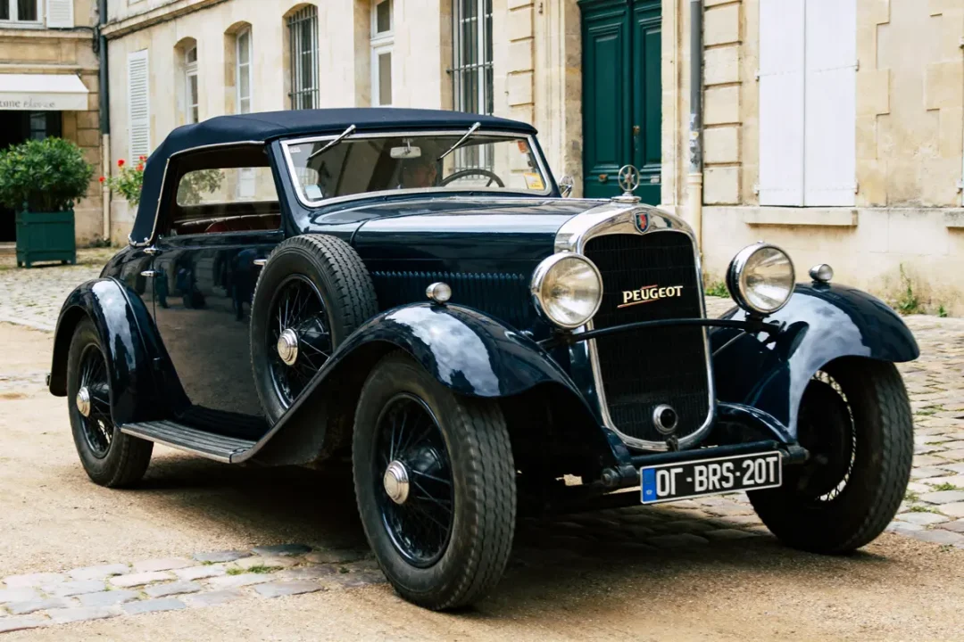 Voiture ancienne noire garée devant un bâtiment en pierre, modèle Peugeot 201 vintage classique