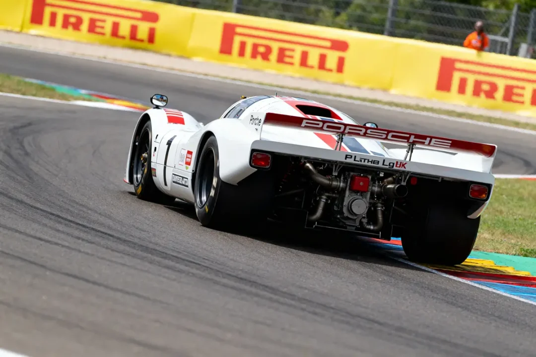 Voiture de course Porsche 917 sur un circuit avec panneaux Pirelli en arrière-plan