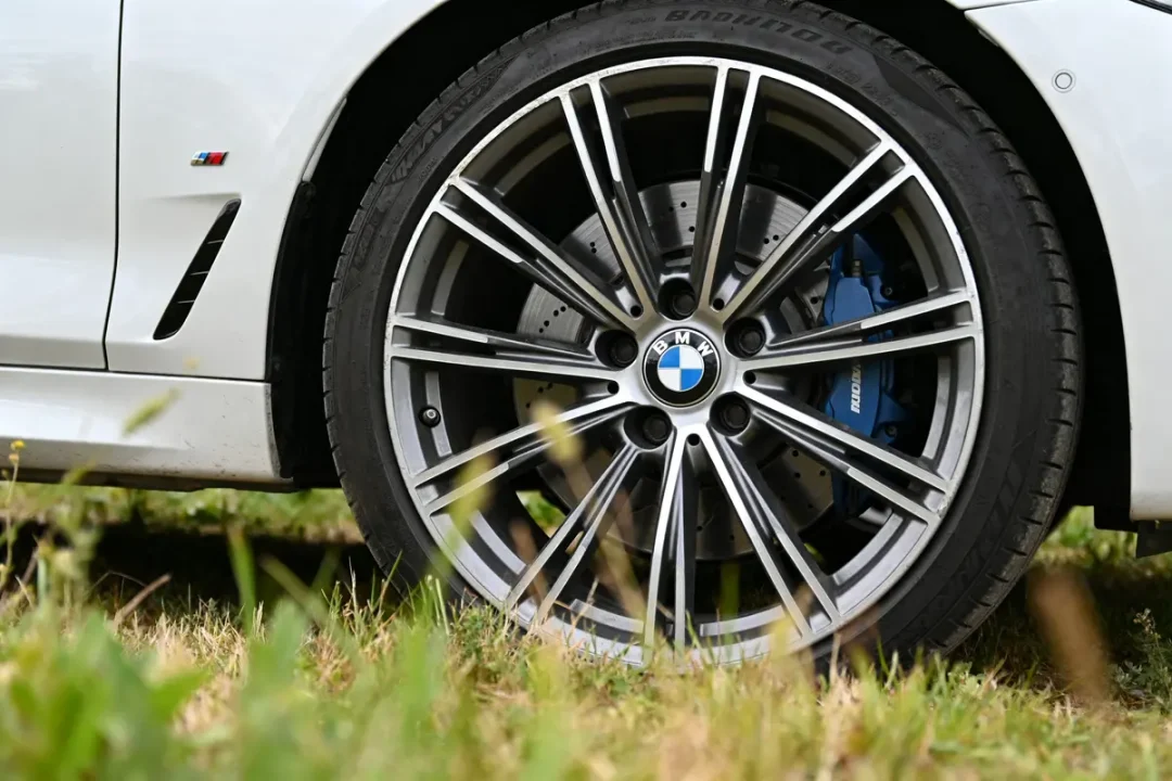 Vue rapprochée d'une roue de voiture et jantes para BMW sur gazon vert