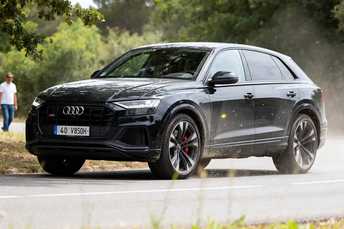 SUV RSQ8 noir roulant sur route entourée de verdure