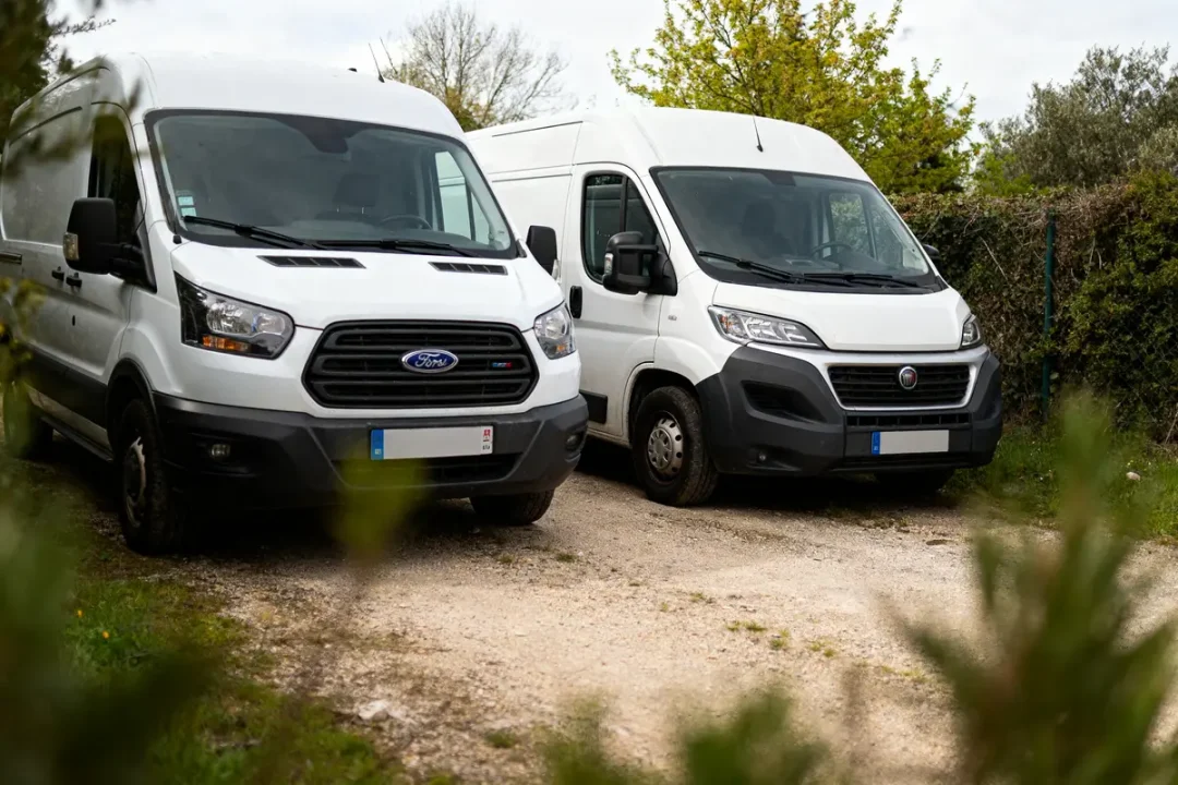 Deux fourgons blancs stationnés considérés au mauvais moteur camping-car à éviter.