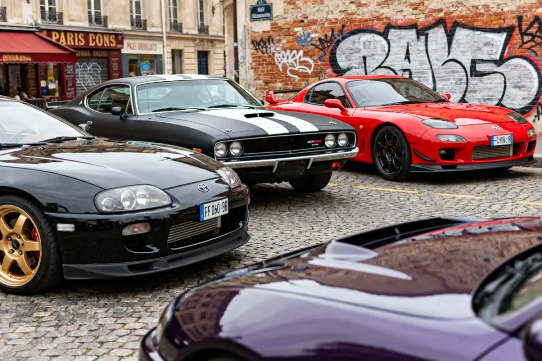 Voitures iconiques de Fast and Furious garées devant un mur de graffitis colorés